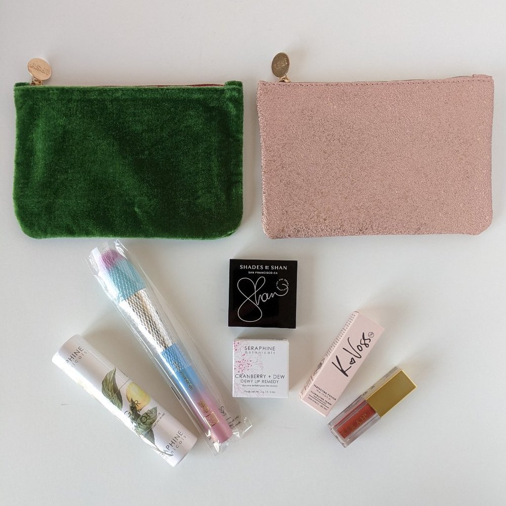 Green and pink IPSY bags with makeup and lip care products